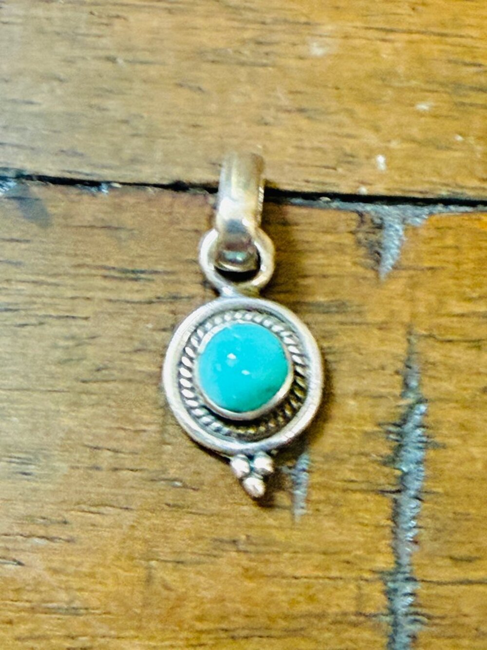 Ornate round bezel-set turquoise cabochon pendant set in solid sterling silver